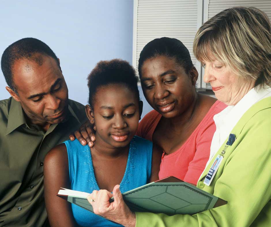 Family looking at book with carer